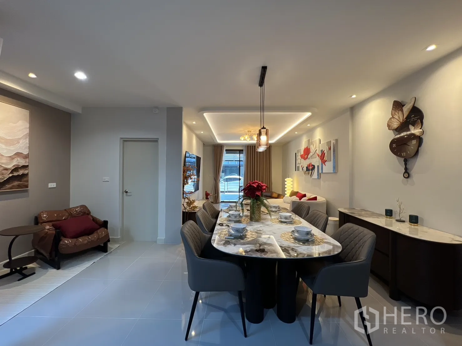 Townhouse for rent in Bang Phli, Samut Prakan - Long dining area with a marble table for six, view toward the living space and front window.