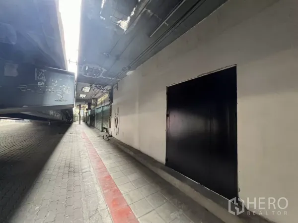 店屋 出售在Suan Luang, Bangkok - 高架桥下带顶人行通道旁的黑色钢制双开大门。