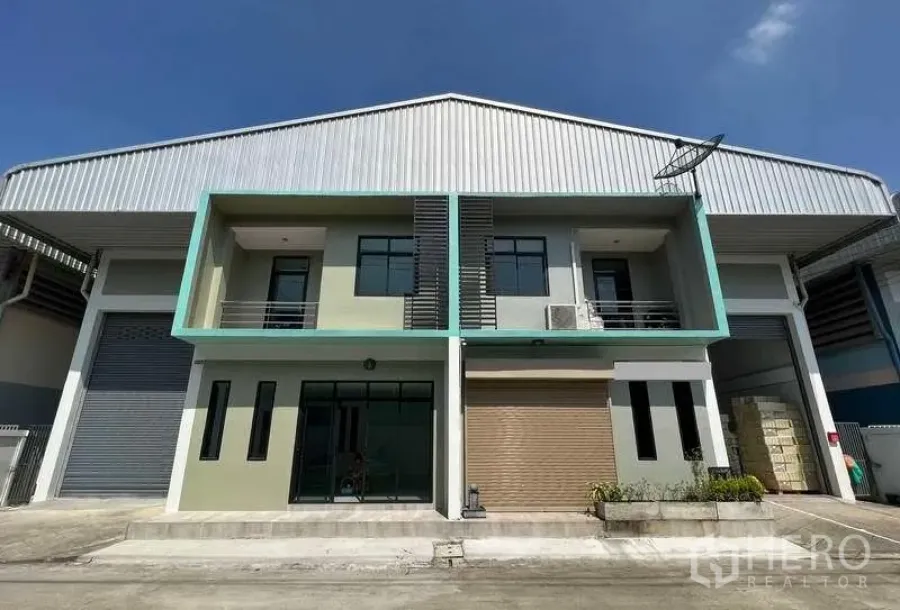 工厂 出租或出售在Mueang Samut Sakhon, Samut Sakhon - 现代工厂外观，带两层办公室、大型卷闸门与玻璃入口，金属屋顶。