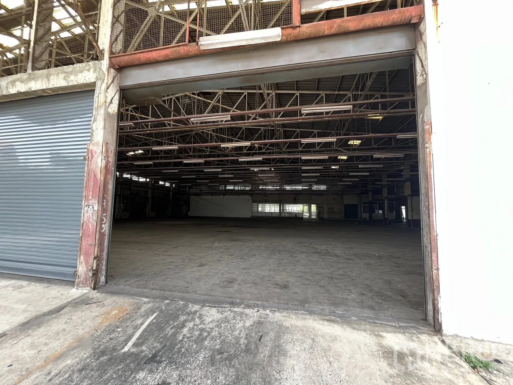 工厂 出租在Phra Pradaeng, Samut Prakan - 宽幅卷闸入口，通向宽敞的仓库内部。