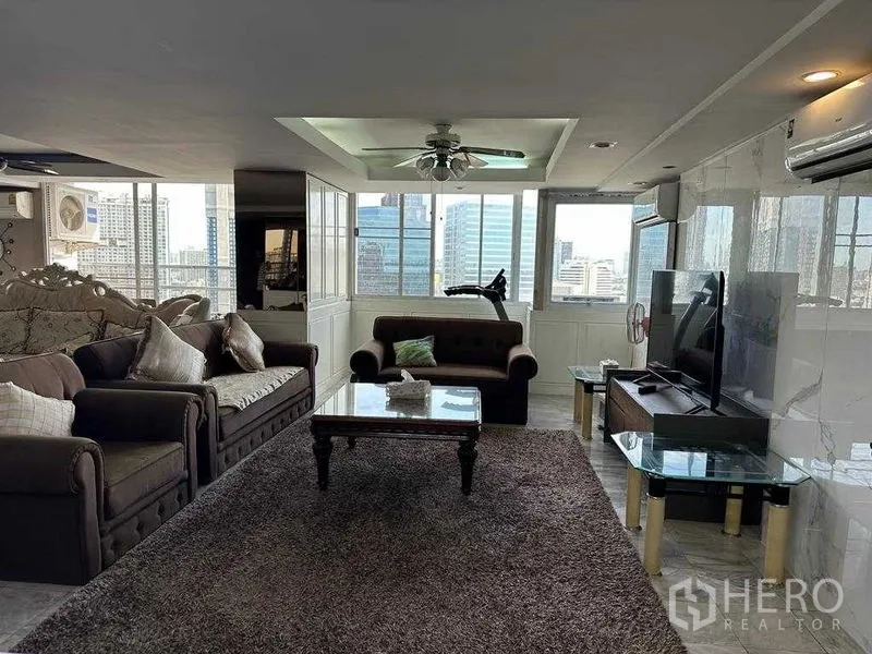 คอนโด ขายในChatuchak, Bangkok - โซนนั่งเล่นพร้อมผนังทีวี พรม และหน้าต่างบานกว้างมองเห็นวิวเมือง