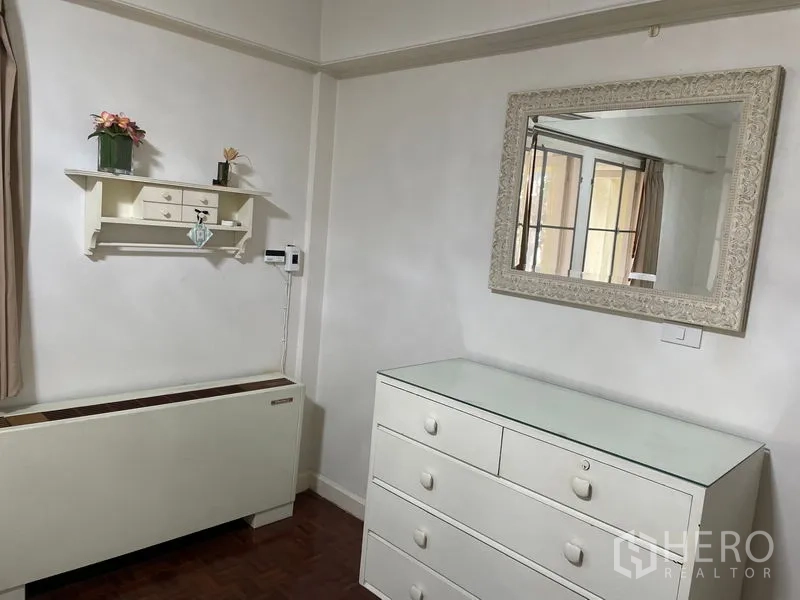 อพาร์ทเมนท์ ให้เช่าในWatthana, Bangkok - มุมห้องพร้อมตู้ลิ้นชักสีขาว กระจกเงาติดผนัง และชั้นตกแต่ง