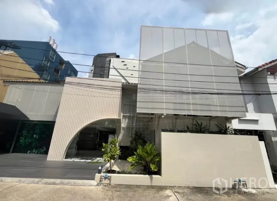 带办公室的家 出租在Bangkok - 翻新两层Home Office外观，穿孔金属屏风立面，车道与绿植，曼谷巴吞旺区。