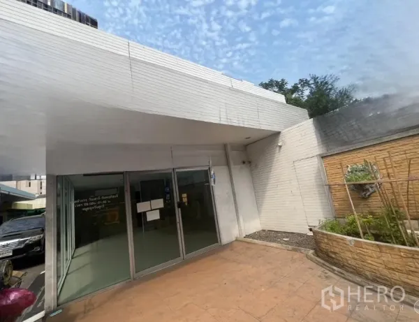 พื้นที่ขายปลีก ให้เช่าในKhlong Toei, Bangkok - มุมมองหน้าร้านพร้อมทางเดินกระเบื้องและแปลงต้นไม้ยกพื้น