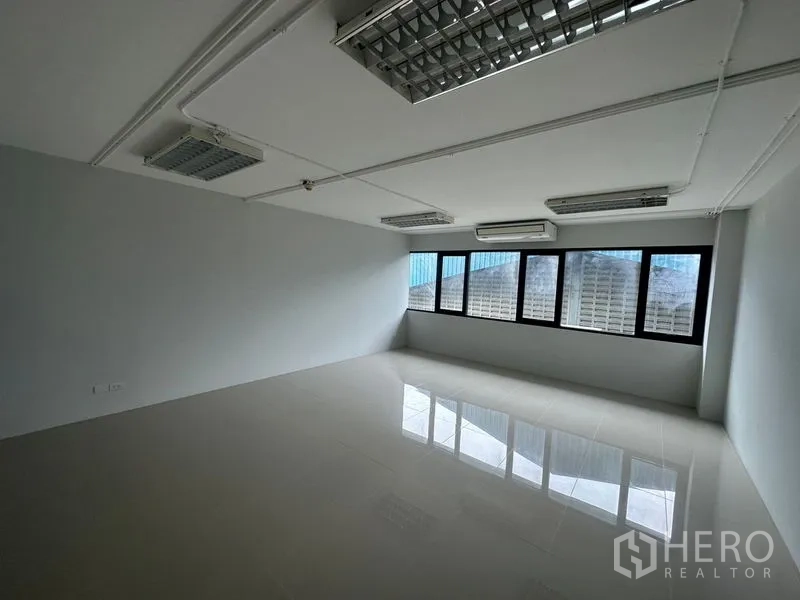 สำนักงาน ให้เช่าในBang Phli, Samut Prakan - ภายในสำนักงานติดแอร์ ผนังสีขาว หน้าต่างกรอบสีดำ พื้นเงา และไฟฟลูออเรสเซนต์