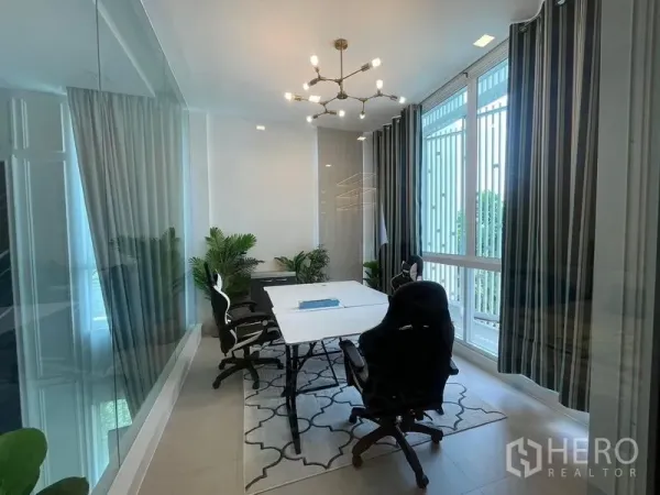 Detached House for rent in Bueng Kum, Bangkok - Glass-enclosed home office with large windows, striped curtains, meeting table, office chairs and potted plants.