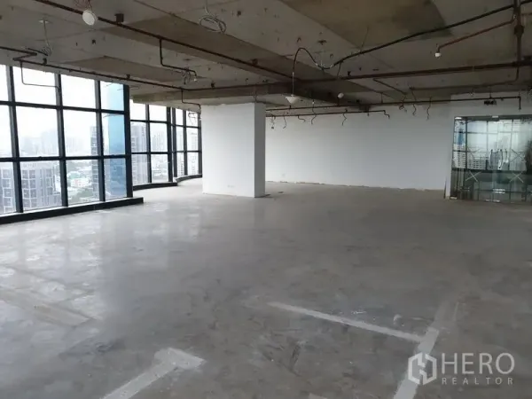 Office Space for rent in Watthana, Bangkok - Large raw office floor with exposed ceiling services and glass entry doors.