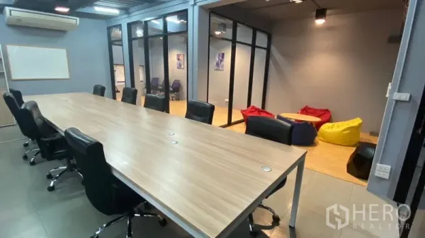 办公空间 出租在Sathon, Bangkok - 玻璃隔断的曼谷办公室内，会议桌面向懒人沙发休闲角。