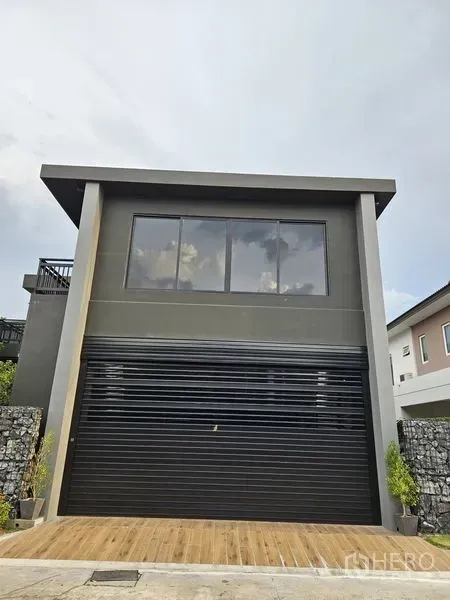 Detached House for sale in Thawi Watthana, Bangkok - Straight-on shot of the double-height garage with a wide roller shutter.