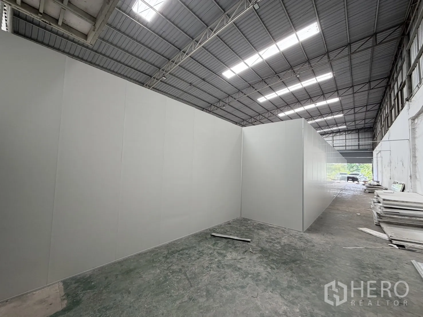 Warehouse for rent in Khlong Luang, Pathum Thani - Interior view showing long panel-built partition rooms under a high metal roof with daylight panels.