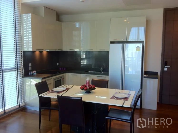 คอนโด ให้เช่าในWatthana, Bangkok - ครัวรูปตัวแอลโทนขาวมันวาว เคาน์เตอร์แบ็กสแปลชสีดำ โต๊ะทานอาหารแบบไอแลนด์ และหน้าต่างบานใหญ่พร้อมบังตา