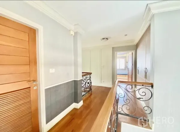 Home Office for rent in Pak Kret, Nonthaburi - Bright upper hallway with wood floors and wrought-iron balustrade leading to bedrooms.