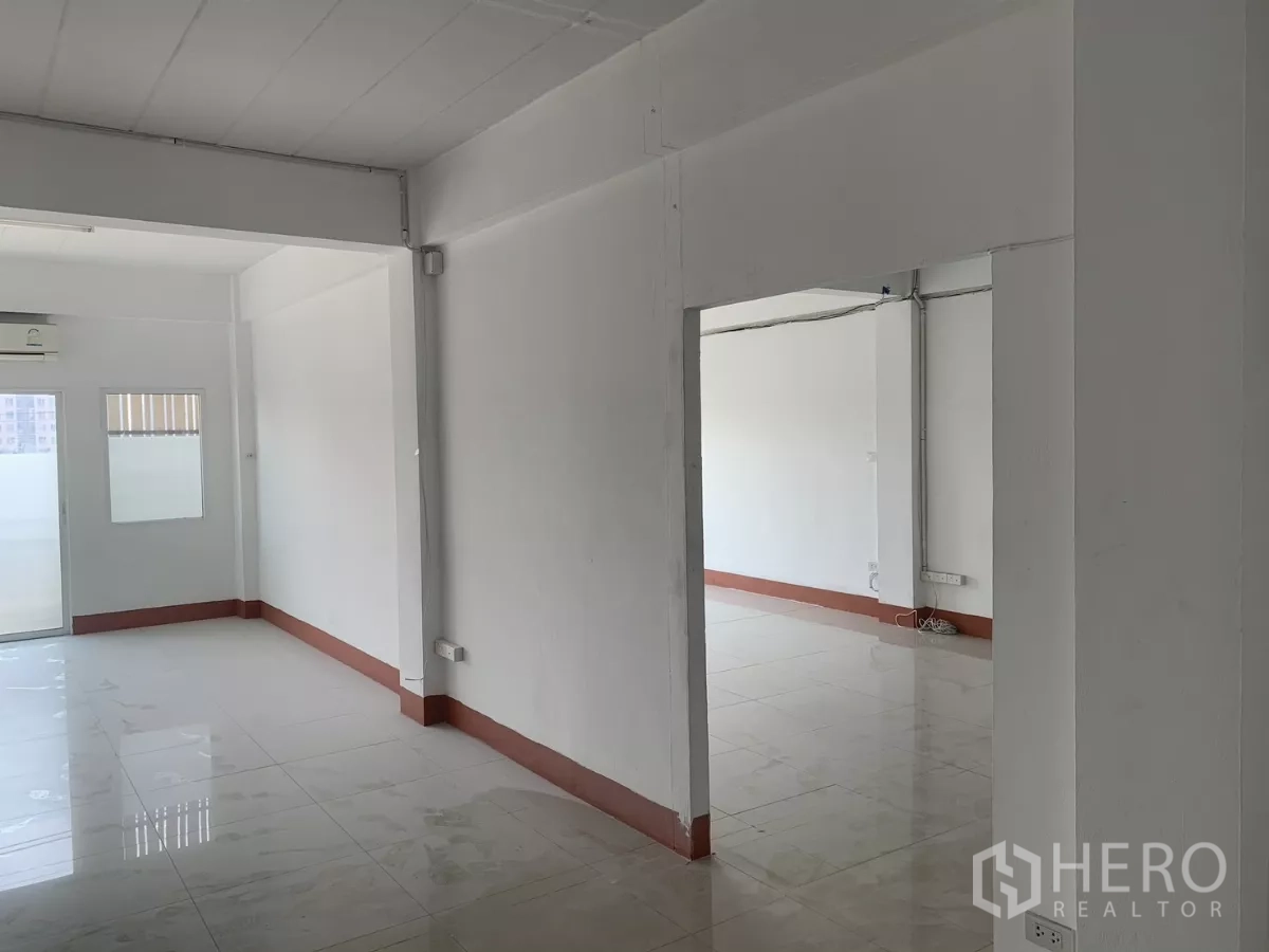 Home Office for rent in Lat Krabang, Bangkok - Interconnected upper rooms with tiled floors, framed opening and balcony access.