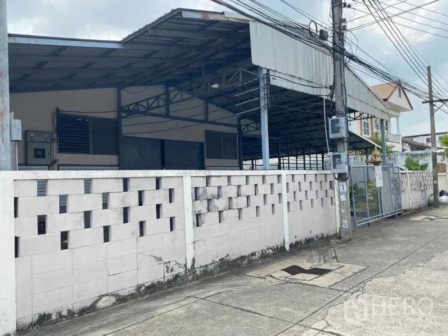 Warehouse for rent in Bang Sue, Bangkok - Street view of gated warehouse with perimeter wall and roofed structure in Bang Sue.