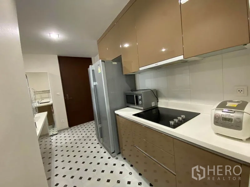 คอนโด ให้เช่าหรือขายในKhlong Toei, Bangkok - ครัวแบบแกลลีย์พร้อมเตาไฟฟ้า ไมโครเวฟ ตู้เย็นสองประตู และตู้บิวท์อินเงา