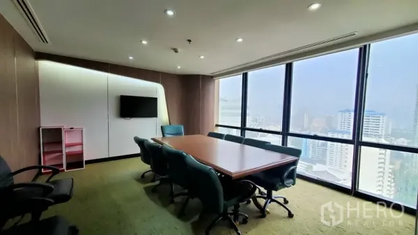 办公空间 出租在Watthana, Bangkok - 董事会议室，长桌、青绿色椅子，落地窗俯瞰天际线。