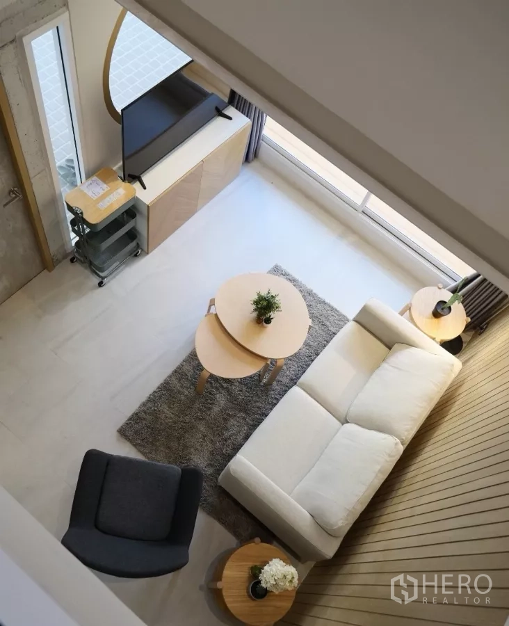 联排别墅 出租或出售在Watthana, Bangkok - 从夹层俯瞰客厅，沙发与圆形茶几一览无遗。