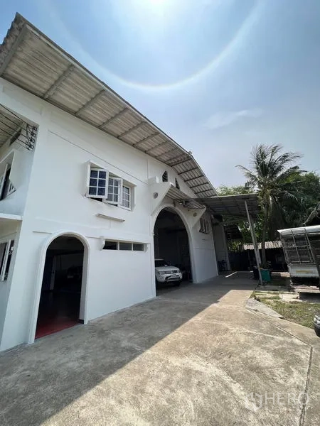 คลังสินค้า ให้เช่าในThung Khru, Bangkok - ด้านหน้าอาคารโกดังสีขาว ช่องโค้ง กันสาดด้านข้าง และทางรถยนต์กว้าง