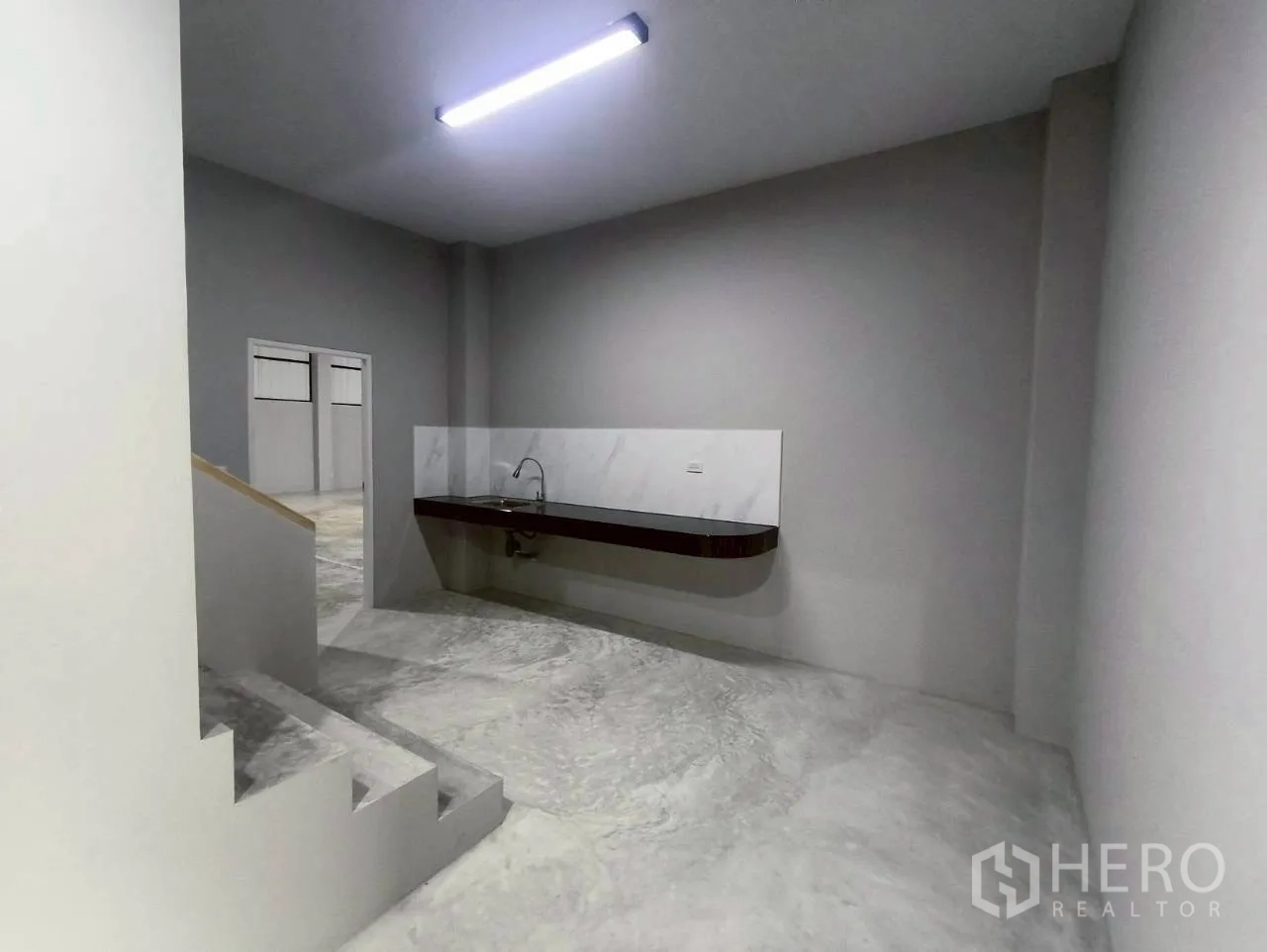 仓库 for rent in Mueang Nonthaburi, Nonthaburi - 一层空间设有水槽操作台与通往楼上的楼梯。