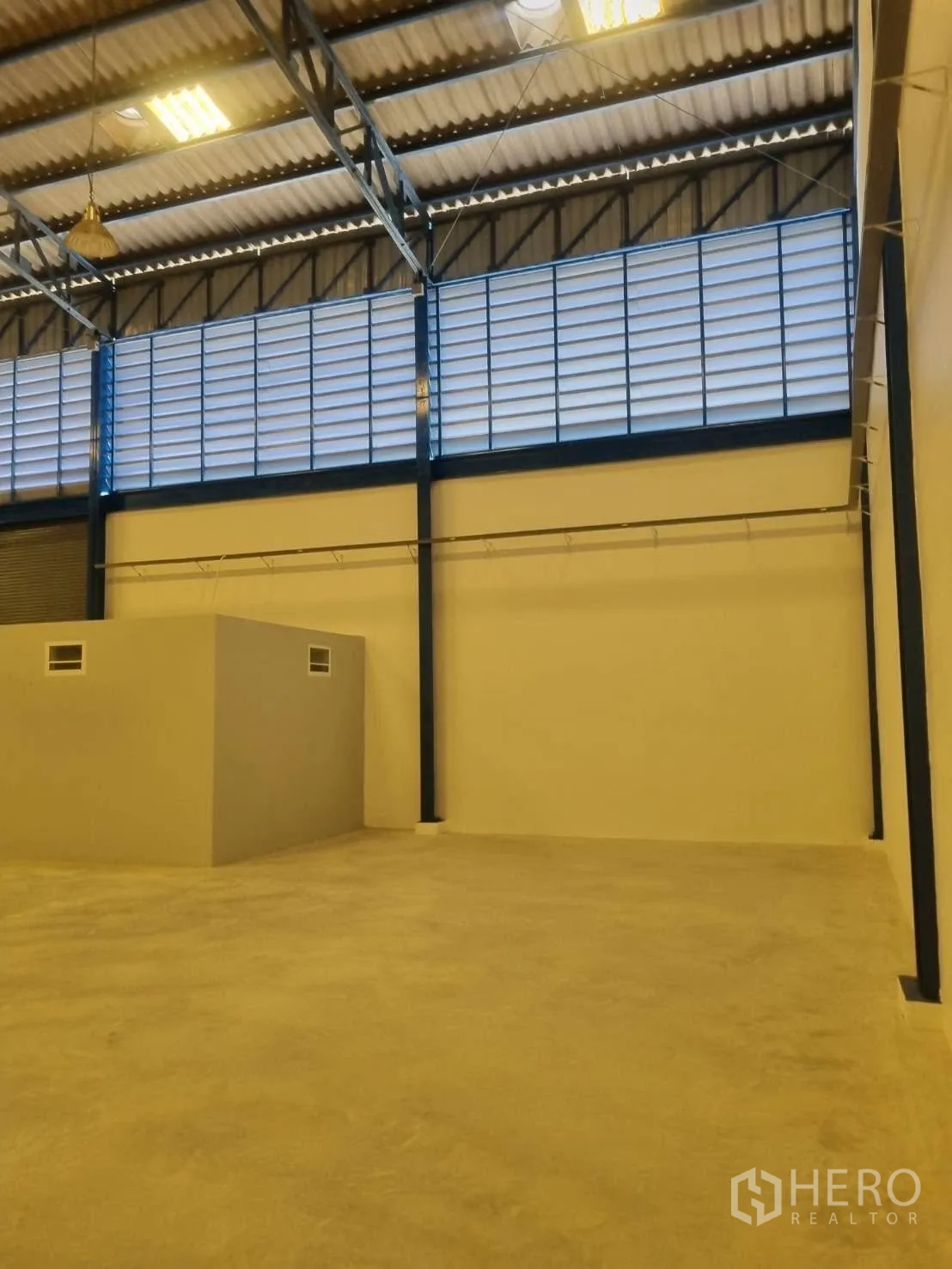 Warehouse for rent in Thepharak, Nakhon Ratchasima - Interior of the warehouse showing high roof, louvered vents, and concrete floor.