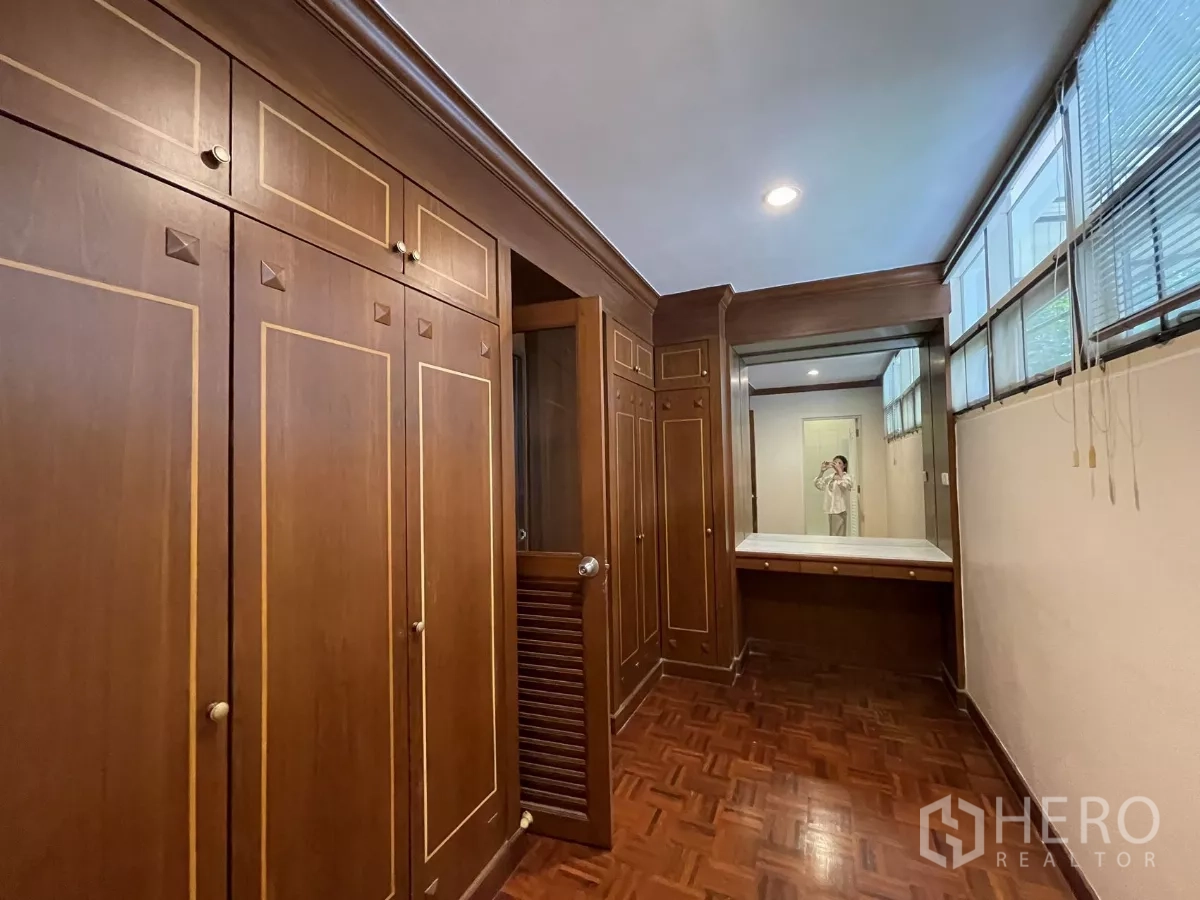 Detached House for rent in Chatuchak, Bangkok - Walk-in closet with custom wooden cabinetry, vanity and parquet flooring.