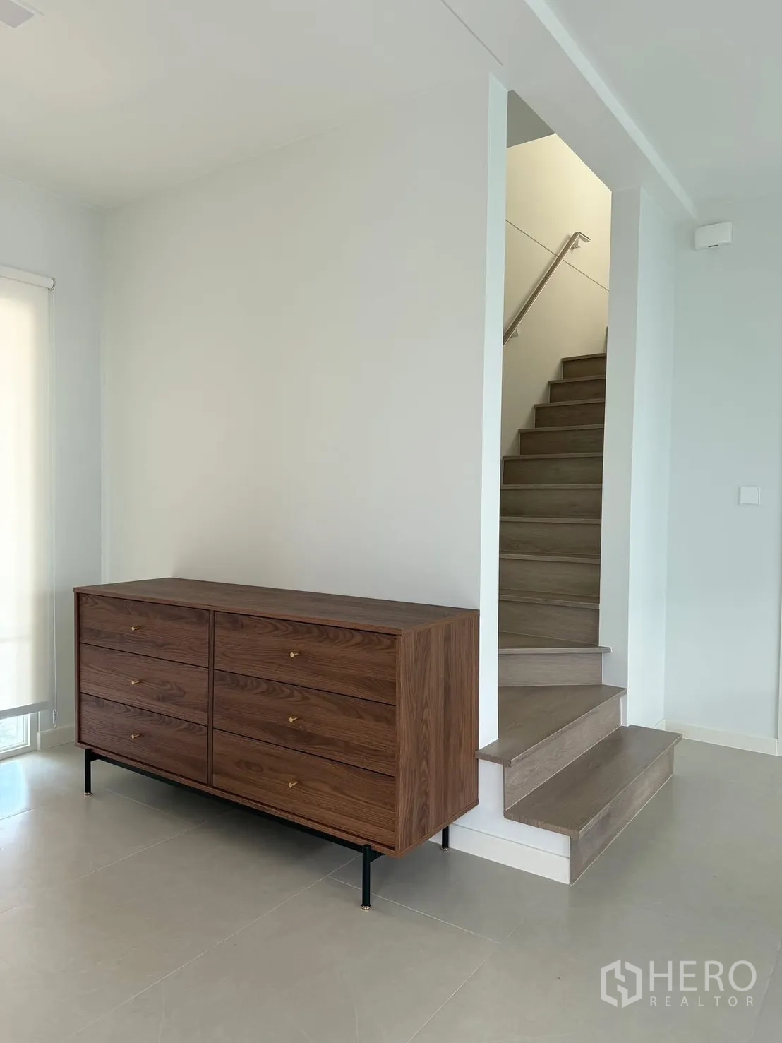 บ้าน ให้เช่าในBang Na, Bangkok - โถงบันไดขั้นไม้ ข้างตู้ลิ้นชักไม้สไตล์โมเดิร์น