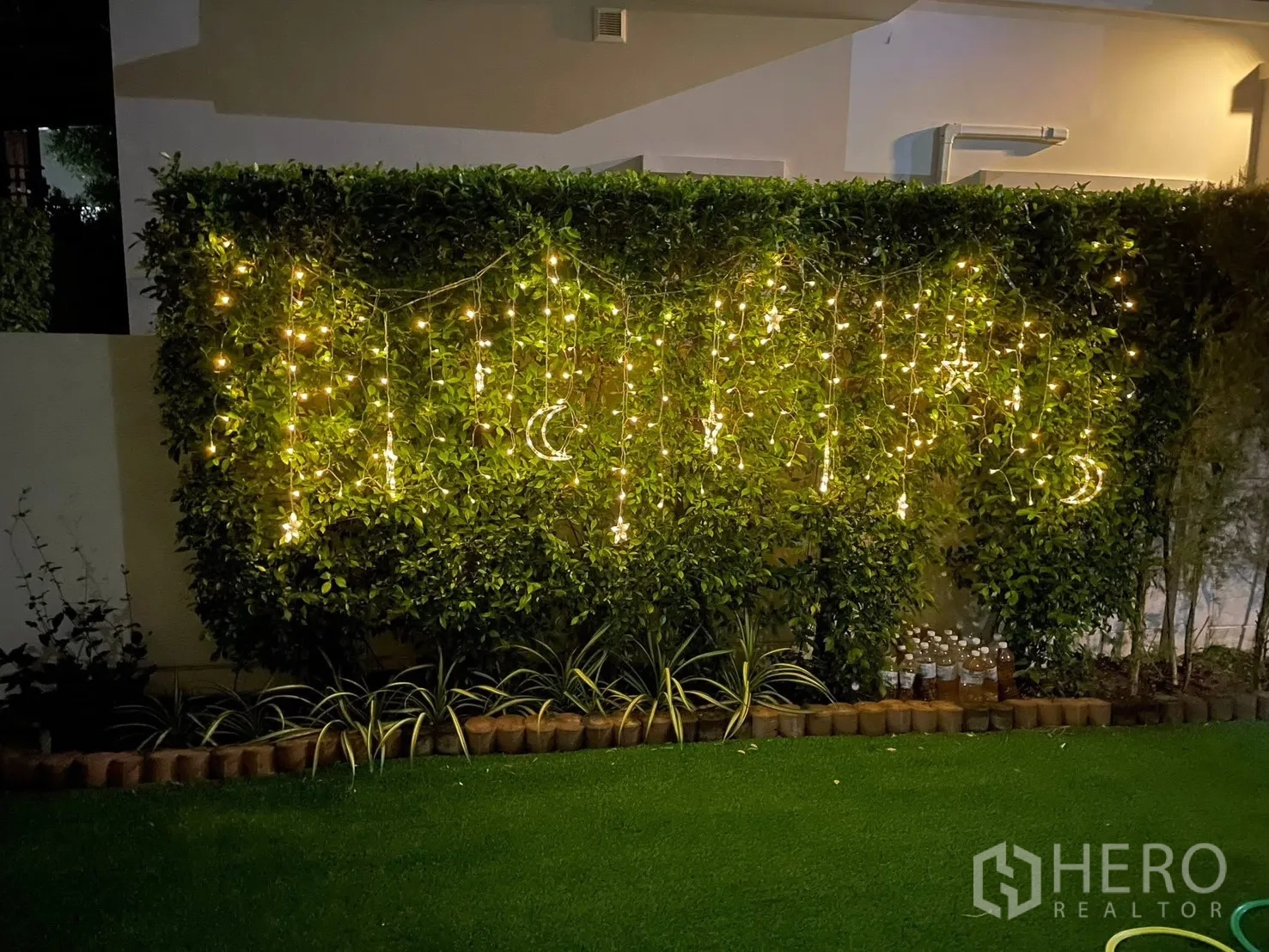 Detached House for rent or sale in Bang Phli, Samut Prakan - Night garden scene with hedge decorated by hanging string lights.