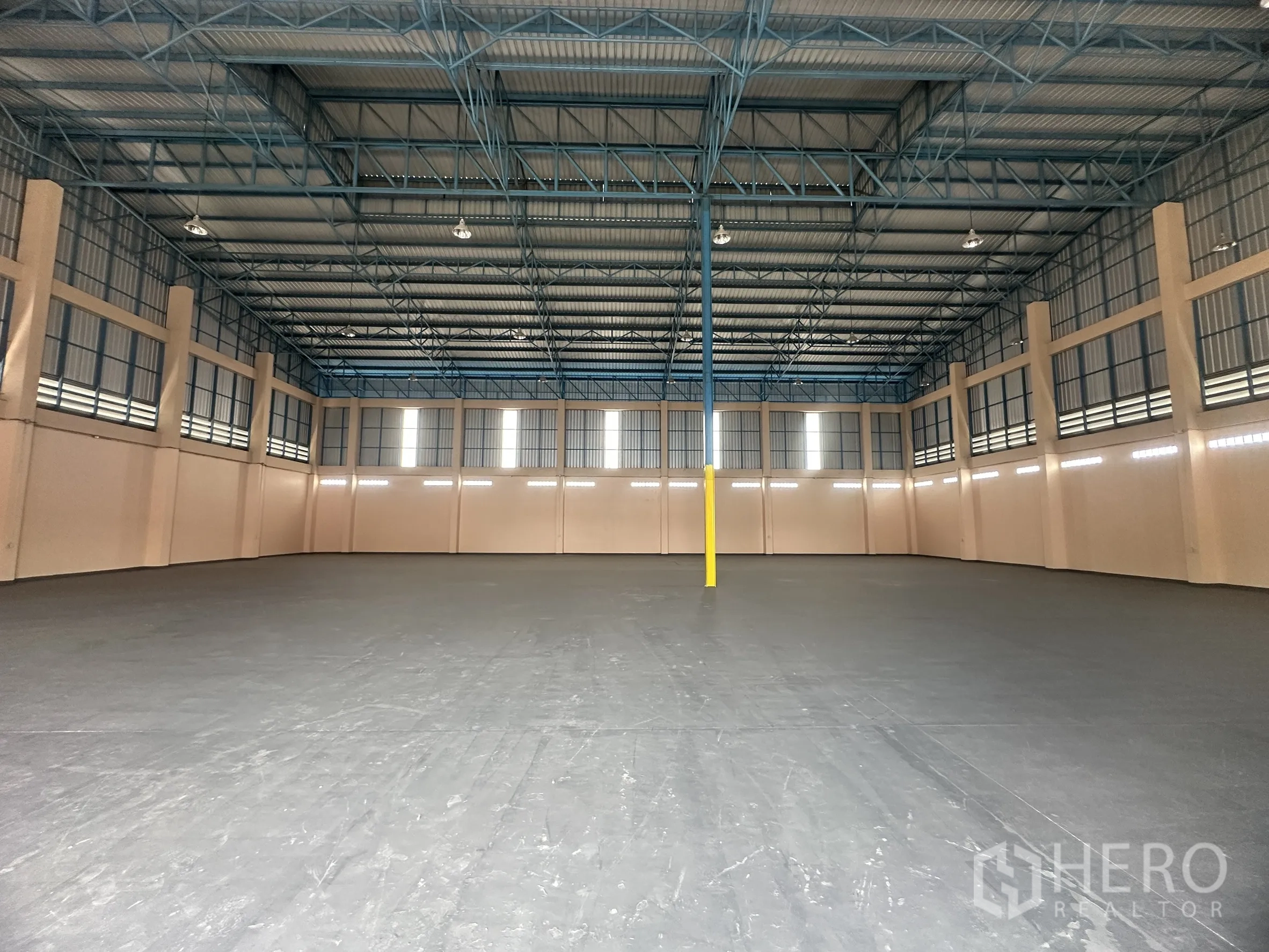 Warehouse for rent in Lat Lum Kaeo, Pathum Thani - Open warehouse hall featuring central column, high ceiling and strip windows for daylight.
