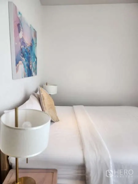 คอนโด ให้เช่าในKhlong Toei, Bangkok - มุมใกล้ของเตียง ปูผ้าสีขาวพร้อมโคมไฟหัวเตียงสีทอง