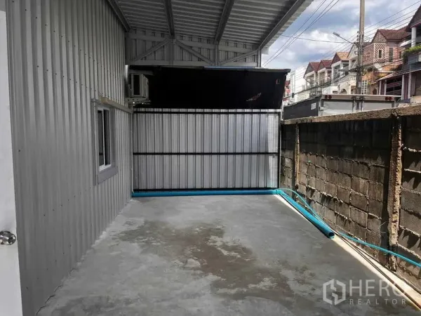 货栈 出租在Lat Phrao, Bangkok - 仓库后侧带顶棚的侧院，混凝土地面与金属围栏，适合作为装卸或设备区。