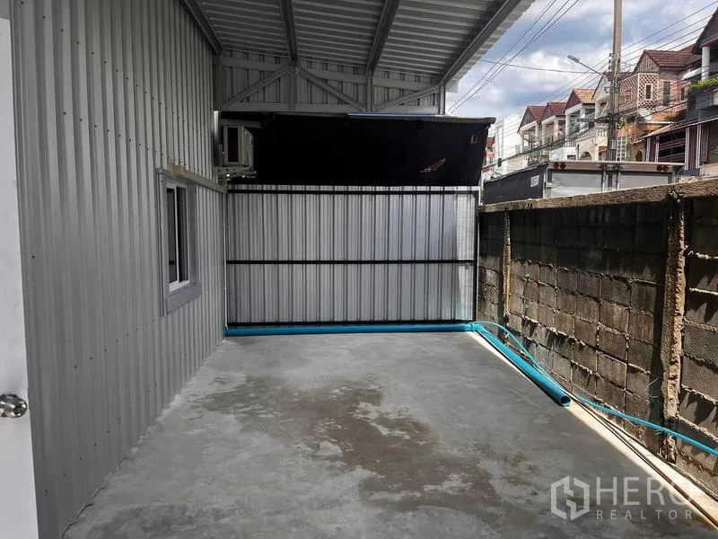 货栈 出租在Lat Phrao, Bangkok - 仓库后侧带顶棚的侧院，混凝土地面与金属围栏，适合作为装卸或设备区。