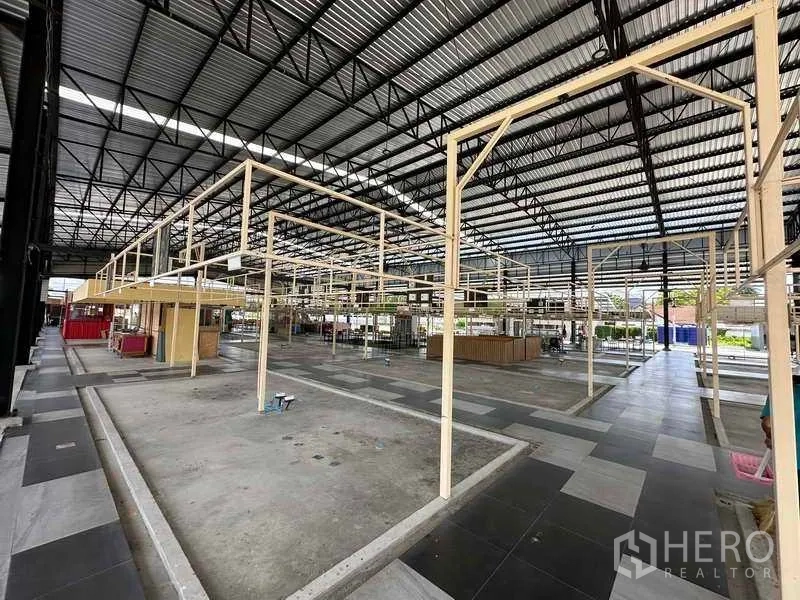 Warehouse for rent in Sai Noi, Nonthaburi - Interior of the warehouse with high truss roof and modular frames for stalls or offices.