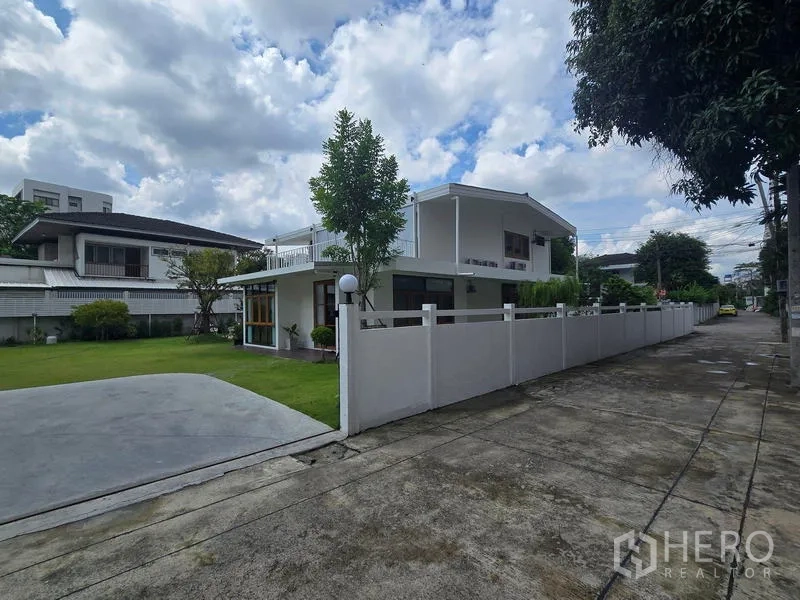 สำนักงานที่บ้าน ให้เช่า - มุมภายนอกบ้านสีขาวสองชั้นและสนามหญ้า ริมซอยเงียบสงบในจตุจักร