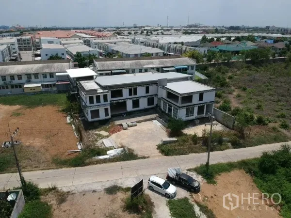 Land for sale in Phra Nakhon Si Ayutthaya, Phra Nakhon Si Ayutthaya - Oblique aerial of the property showing the building, parking area, and surrounding residential neighborhood.