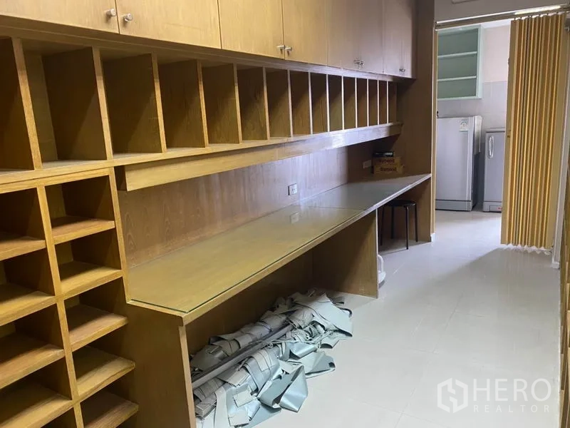 办公空间 出租在Din Daeng, Bangkok - 长形储物间，木质格子柜与玻璃台面，通往茶水间。