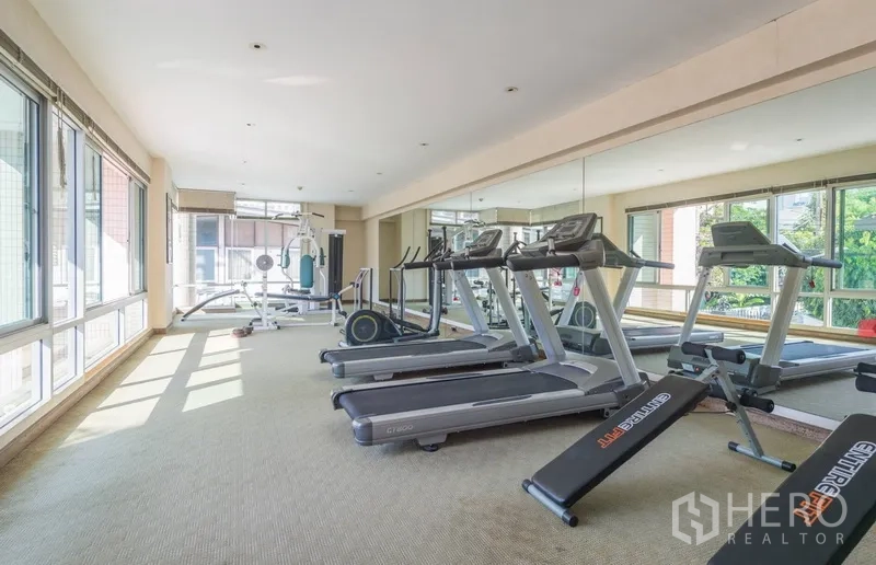 Condominium for rent in Pathum Wan, Bangkok - Fitness center with treadmills, weight machines and wall-length mirrors.
