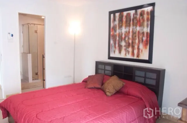 คอนโด ให้เช่าหรือขายในWatthana, Bangkok - ห้องนอนพร้อมผ้าปูเตียงสีแดง งานศิลป์ผนัง และทางเข้าห้องน้ำในตัว