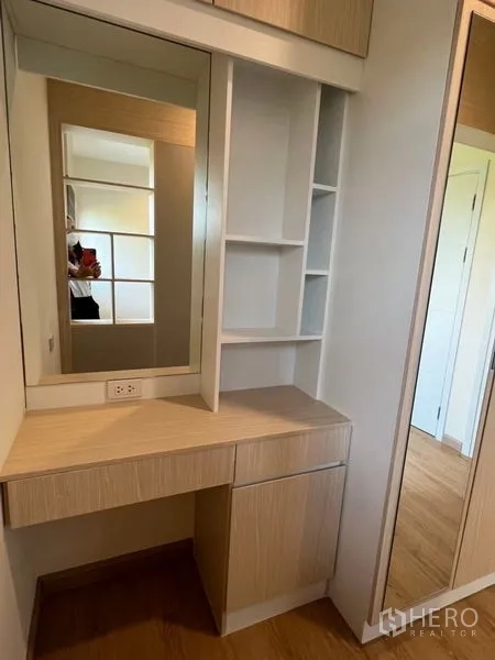 Townhouse for rent - Light wood vanity with mirror and open shelving next to a sliding wardrobe door.