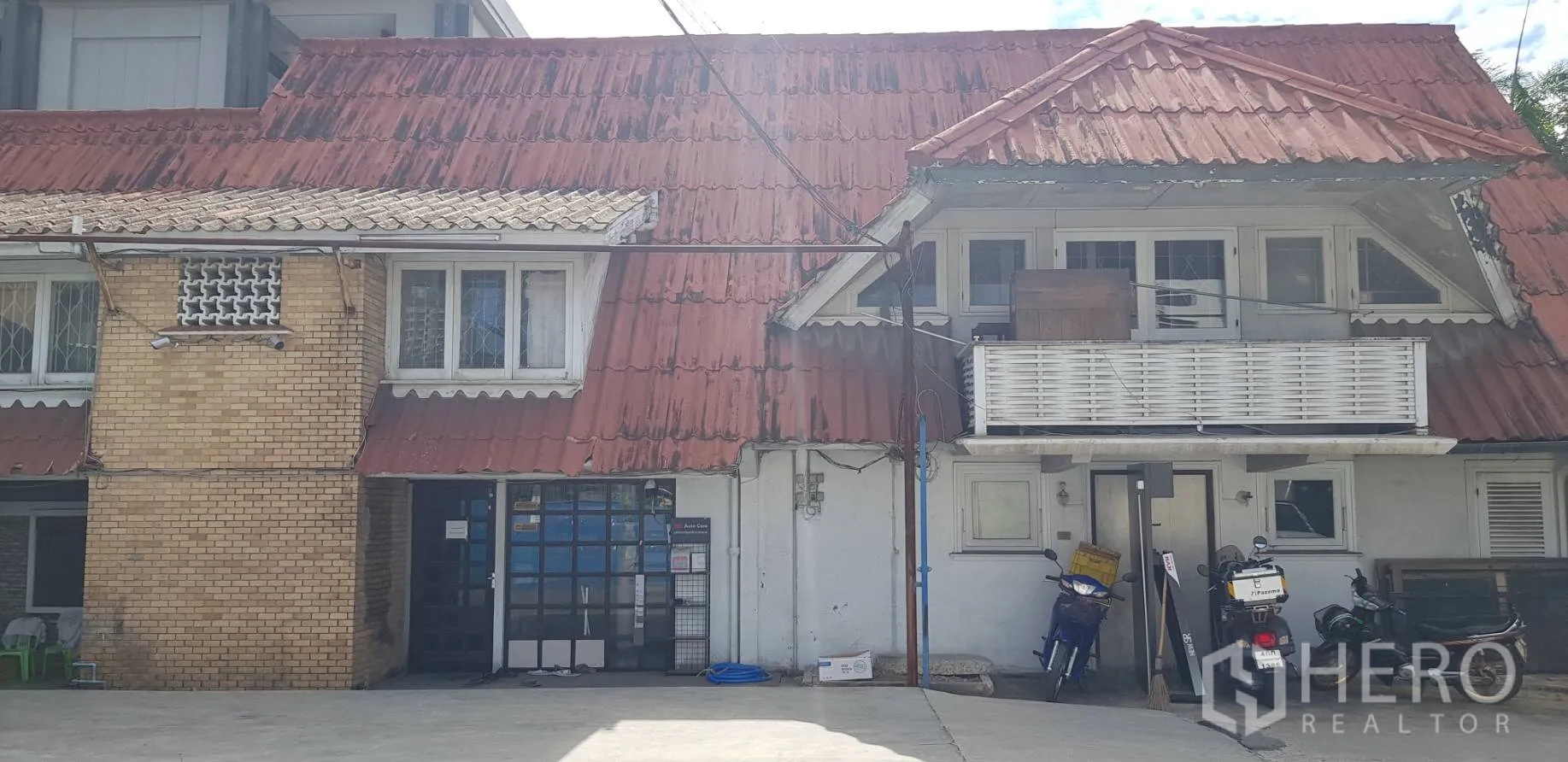 ทาวน์เฮาส์ ให้เช่าในKhlong Toei, Bangkok - ด้านหน้าทาวน์เฮ้าส์สองชั้น หลังคากระเบื้องสีแดง มีระเบียงและลานคอนกรีต