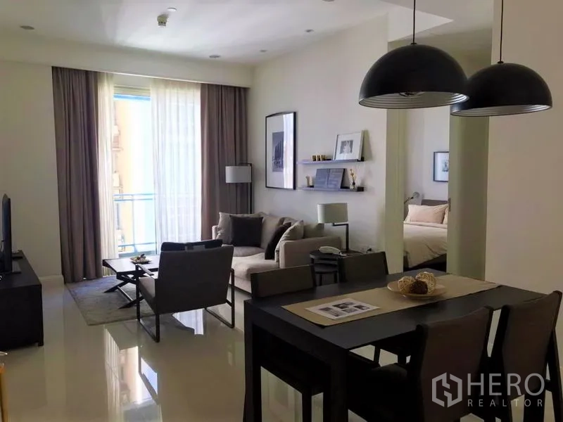 คอนโด ให้เช่าในPathum Wan, Bangkok - พื้นที่นั่งเล่นและรับประทานอาหารแบบเปิดโล่ง มีหน้าต่างบานสูง โคมแขวน และทางเข้าห้องนอน