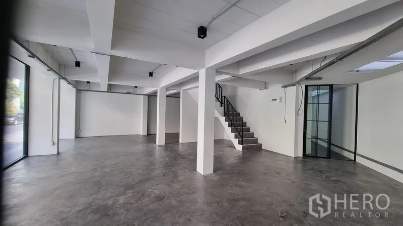 อาคารพาณิชย์ ให้เช่าในKhlong Toei, Bangkok - โถงร้านค้ากว้าง โปร่งแสงจากกระจกสูงจรดพื้น พร้อมบันไดขึ้นชั้นบน.