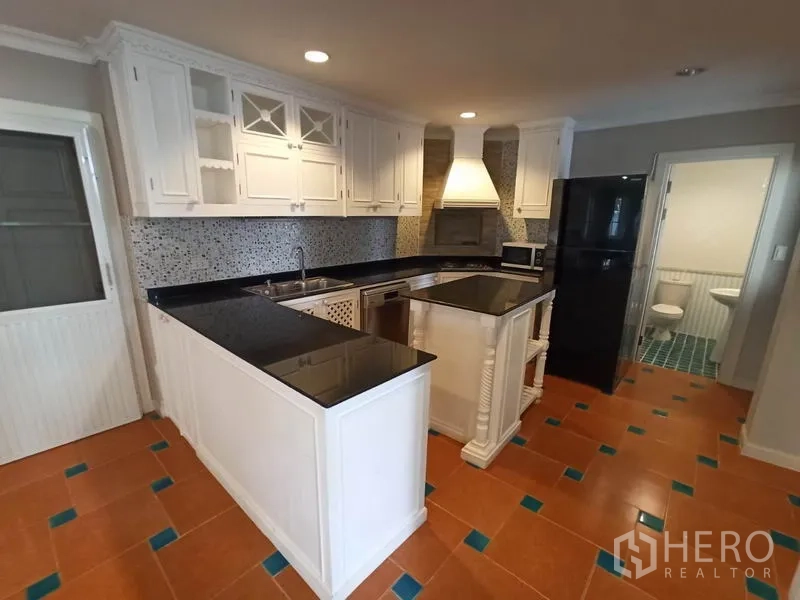 独立式住宅 出租在Mueang Samut Prakan, Samut Prakan - L形厨房配中岛、油烟机、冰箱，并可通往客用卫浴。