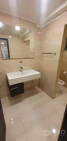 零售空间 出租在Watthana, Bangkok - 干净卫生间，大镜面与壁挂式洗手台，米色瓷砖，可见部分坐便器