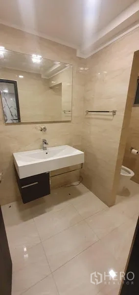 零售空间 出租在Watthana, Bangkok - 干净卫生间，大镜面与壁挂式洗手台，米色瓷砖，可见部分坐便器