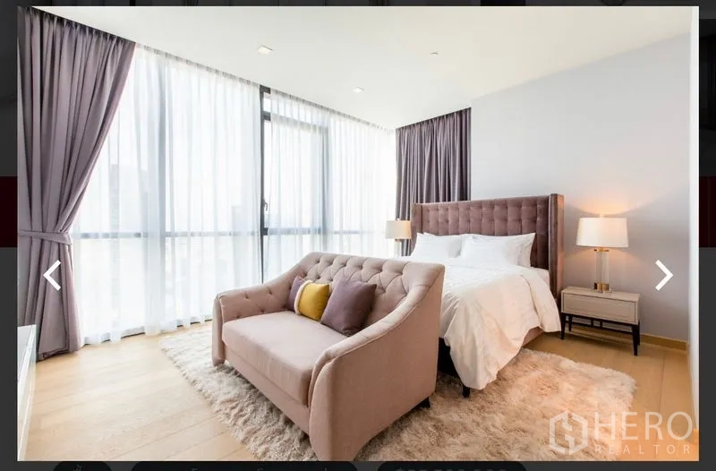 คอนโด ให้เช่าหรือขายในWatthana, Bangkok - ห้องนอนมุมกระจกกว้าง พร้อมโซฟาปลายเตียงและผ้าม่านนุ่ม