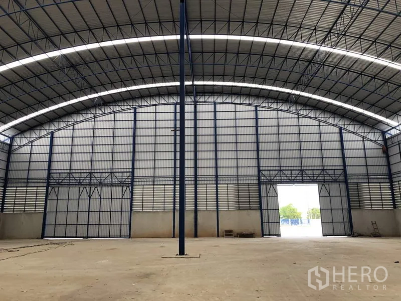 Factory for rent or sale in Lat Lum Kaeo, Pathum Thani - End wall of the warehouse with tall doors and a single central steel column.