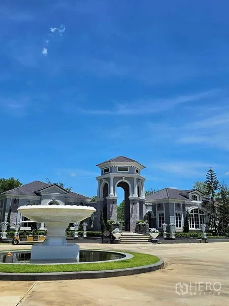 Detached House for rent in Thanyaburi, Pathum Thani - Grand gated community entrance with archway, fountain and landscaped roundabout