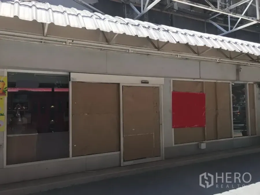 零售空间 出租在Watthana, Bangkok - 临街商铺外观，玻璃门面与白色金属雨棚，前方有人行通道。
