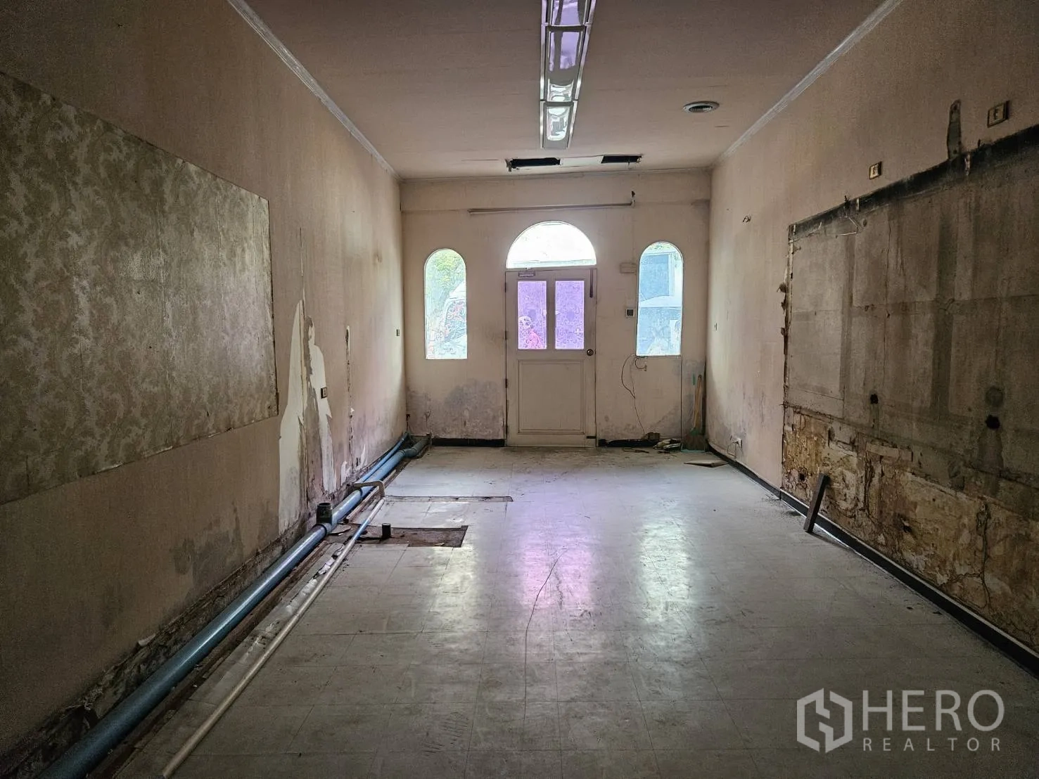 店屋 出租在Watthana, Bangkok - 纵深开间的店铺，外露管线与拱形窗的后门。