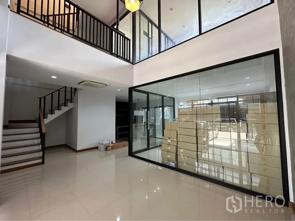 Townhouse for rent in Pak Kret, Nonthaburi - Double-height lobby with central glass meeting room and staircase.